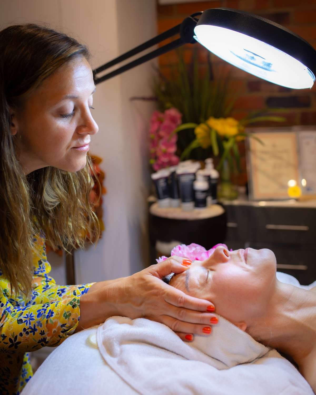 alma performing facial massage under a light