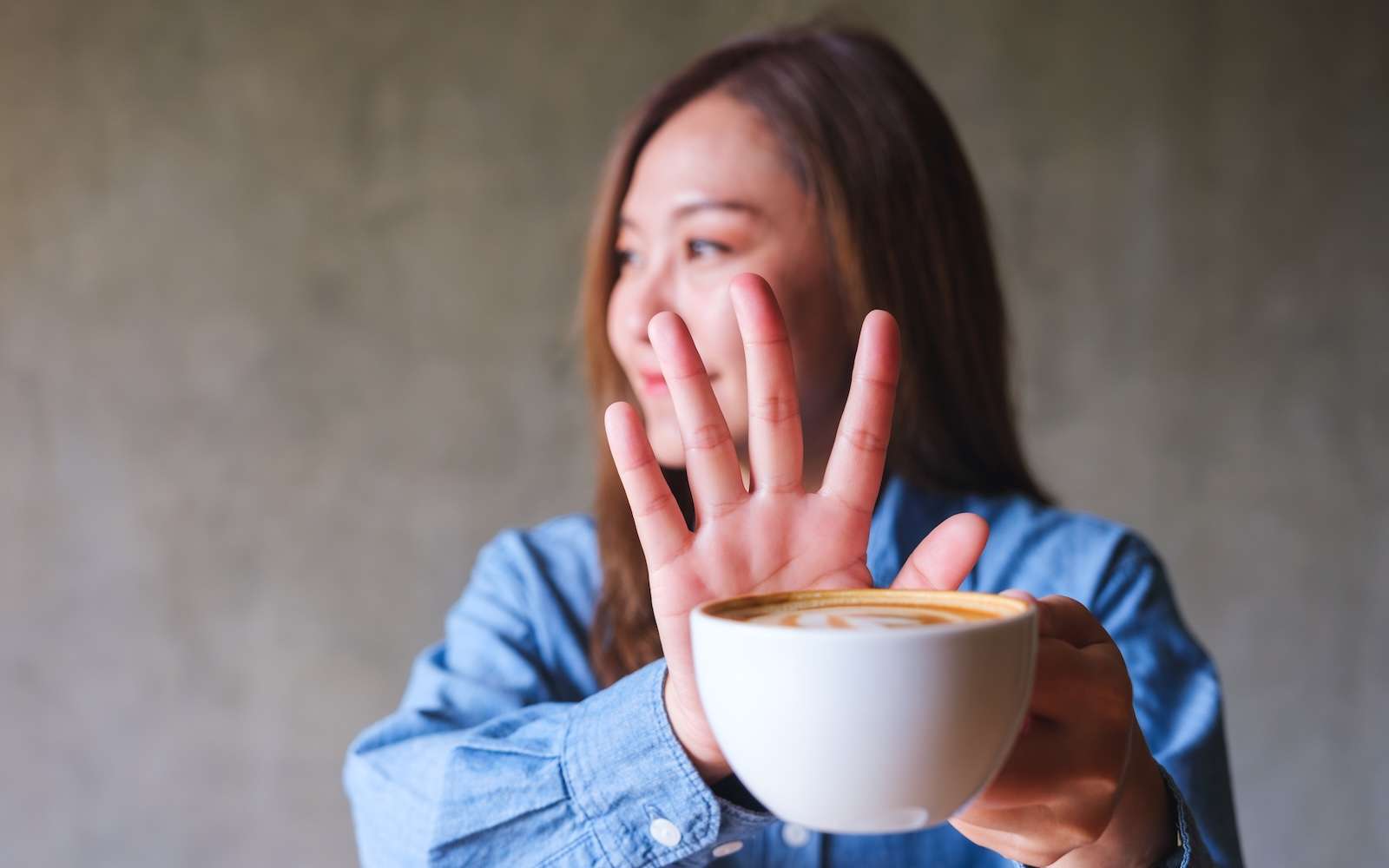 Woman refusing coffee to protect lymphatic system and support lymph fluid flow after lymphatic drainage massage