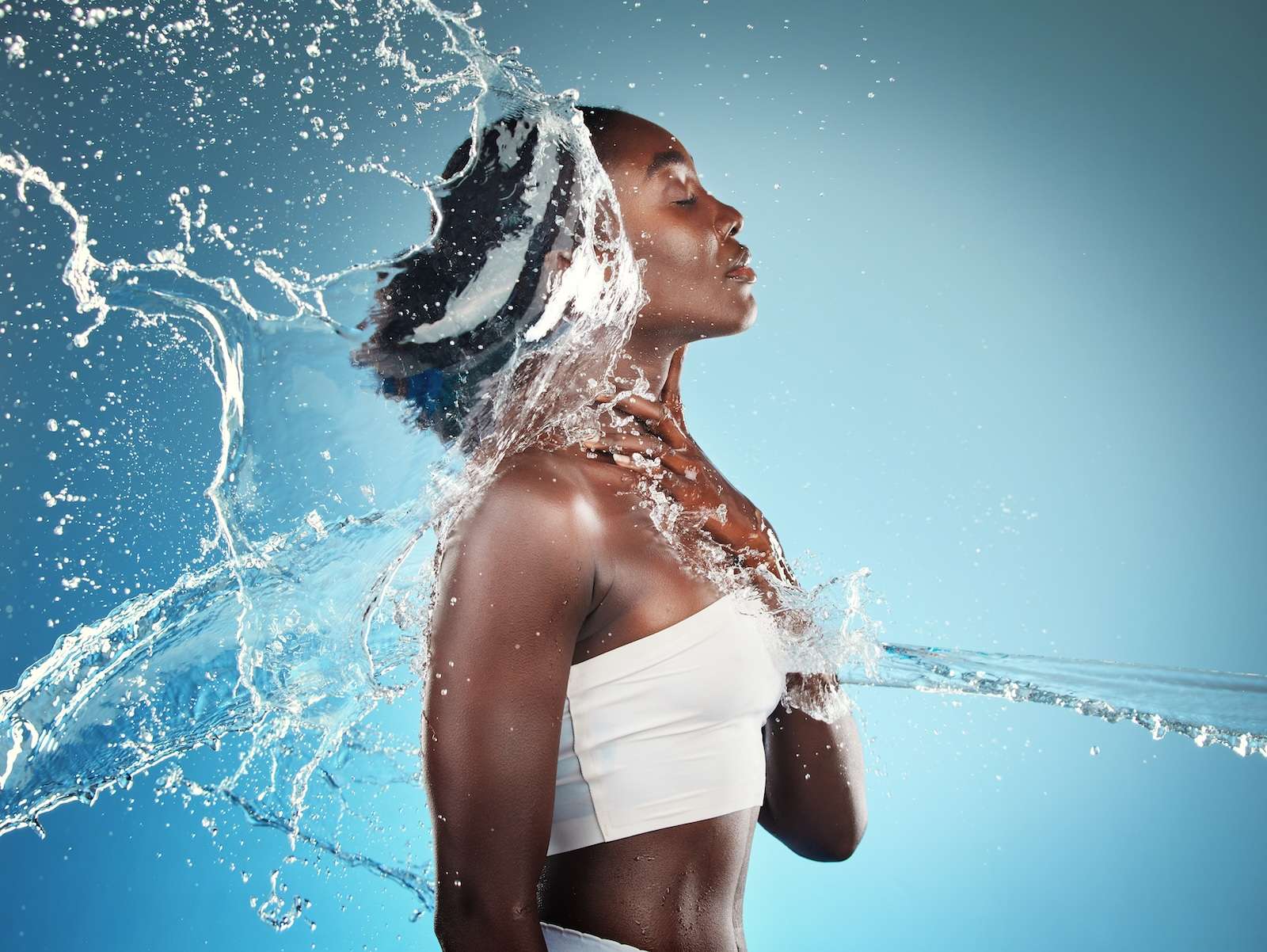Woman splashed with water representing skincare routine to hydrate skin and refresh dry skin and dull skin on the skin's surface
